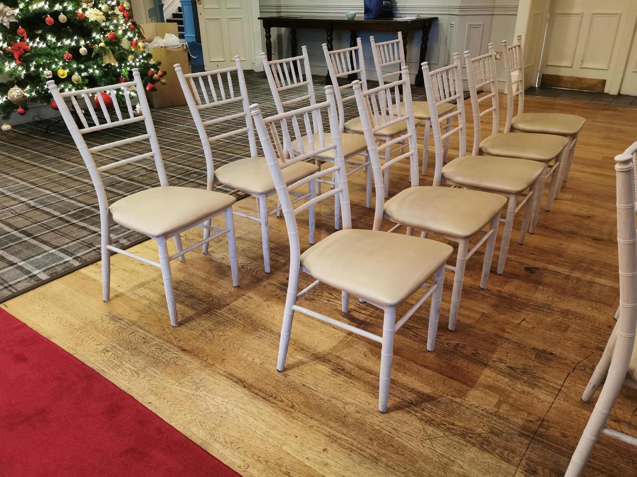 Collection of ten Chiavari bleached oak effect powder coated aluminium wedding venue chairs with upholstered seats